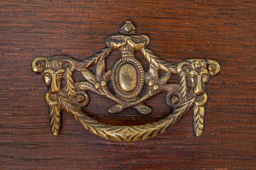 Closeup view of elegant antique drawer cabinet brass handle with goat or cow head
