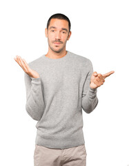 Fototapeta premium Hesitant young man pointing at you with his finger