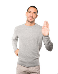 Naklejka premium Happy young man making a gesture of stop with his palm