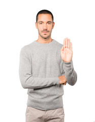 Happy young man making a gesture of stop with his palm