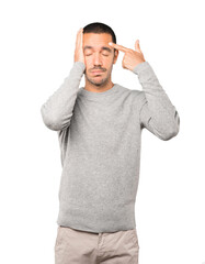 Depressed young man making a suicide gesture