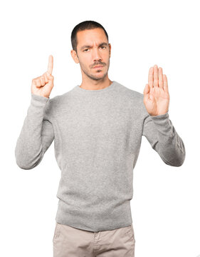 Serious young man making a gesture of stop with his palm