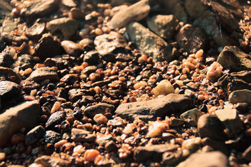 Close up of the texture and pattern of small pebbles on the beach