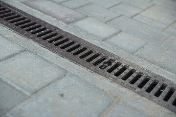 Drainage system with stainless steel composite grating between paving slabs.