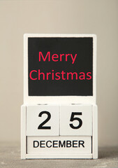 Wooden calendar set on the 25 of December. Merry christmas