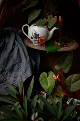 Broken vintage porcelain teapot on a coffee table shot in low light