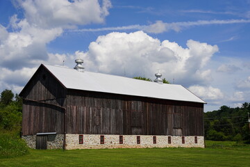 Obraz premium Rustic farmhouse barn sits on countryside