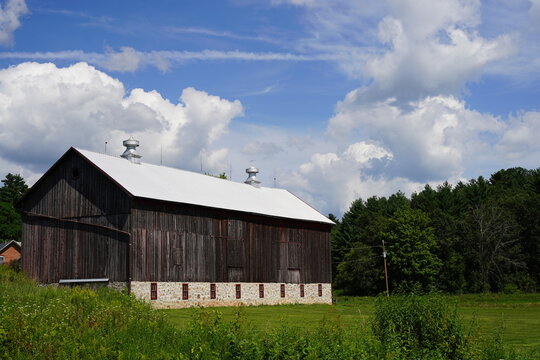 Rustic farmhouse barn sits on countryside
