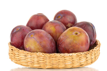 Several juicy plums on a straw plate, macro, isolated on a white background.
