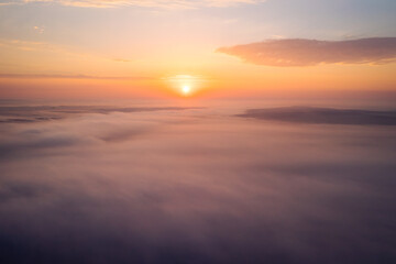 Bird's eye view of the fantastic ocean of clouds at sunrise. Aerial photography, drone shot.