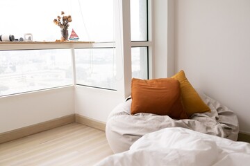 Relaxed bean bag sofa in the living room apartment with big windows.