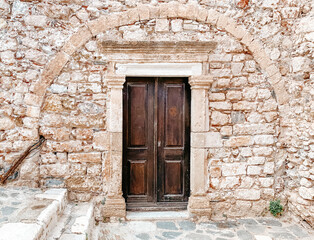 Fototapeta na wymiar Wooden doorway to stone building in Monemvasia, Greece