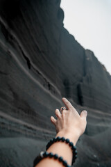 a female hand with bracelets and a ring on her finger indicates the direction to a mountain canyon...