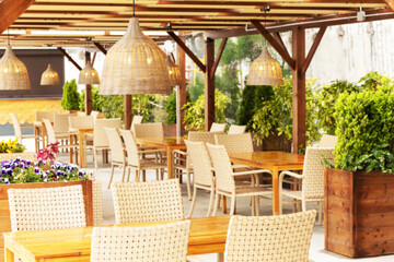 Outdoor cafe with wicker furniture and lamps. Blurred image