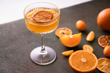orange vodka tequila gin tonic mandarin cocktail with special cocktail glass, dried oranges kumquats on background