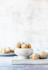 Traditional Indian festival sweets with coconut flakes on wooden board, light background. Laddoo or Laddu, Popular sweet snack in India. Vegan sweets.