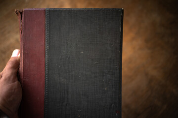 The hand holds an old book. Vintage library. An old encyclopedia.