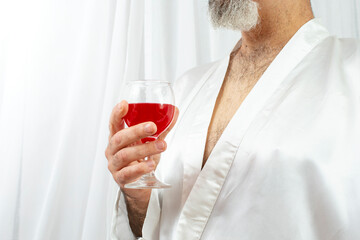 Middle aged man holding a glass of red wine