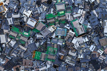 Many SIM card tray backgrounds and SD card trays are prepared for mobile phone repair parts in Top View and Copy Space for messages. Electronic waste that can be used to extract precious metals