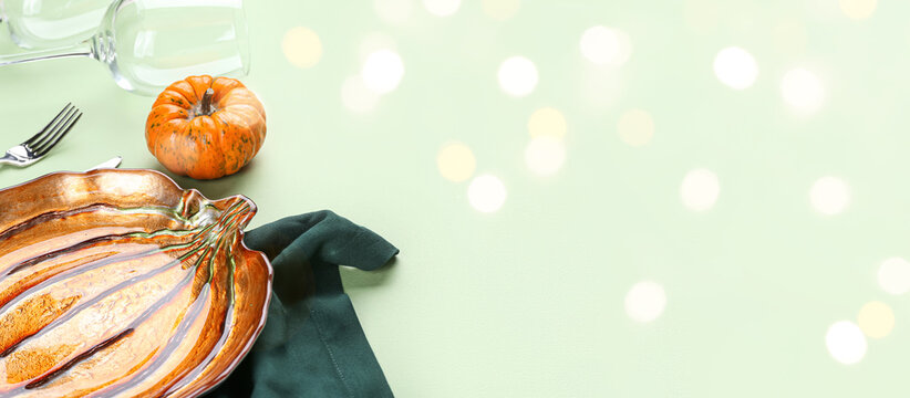 Beautiful autumn table setting on green background with space for text