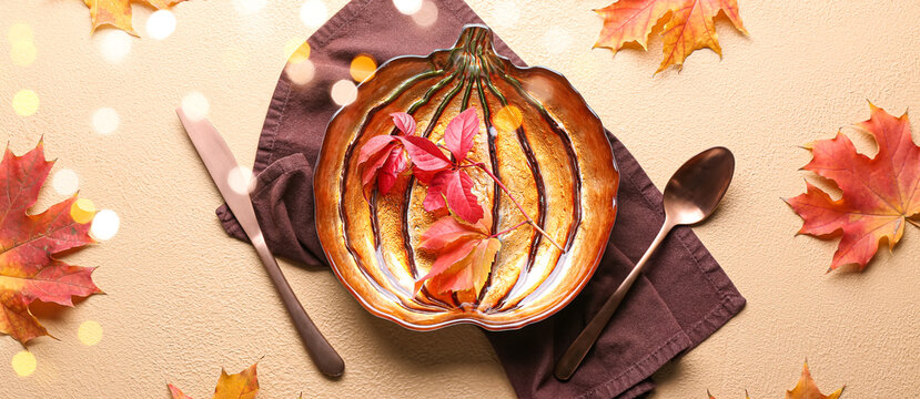Beautiful table setting with autumn leaves on beige background