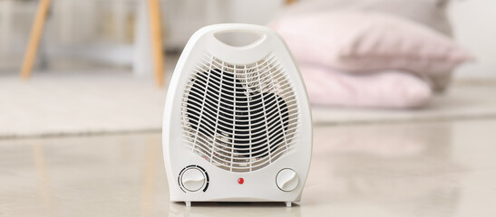 Electric fan heater on floor in room