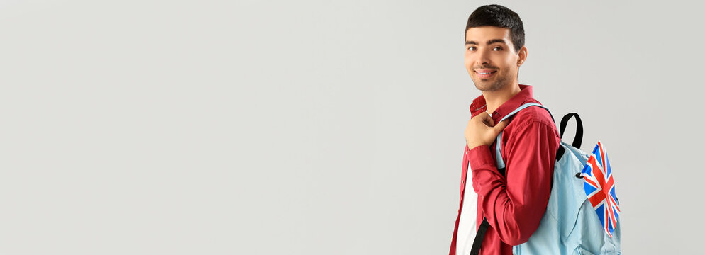 Young man with UK flag and backpack on light background with space for text - Powered by Adobe