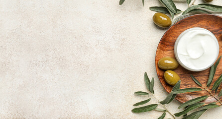 Jar of cream with olive oil extract on light background with space for text, top view