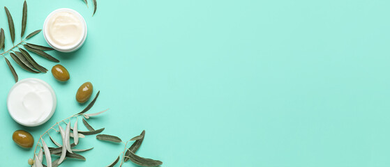 Jars of cream with olive oil extract on turquoise background with space for text, top view