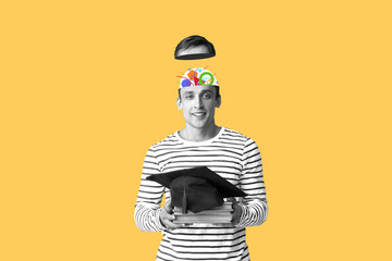 Smart man with graduation hat and books on yellow background