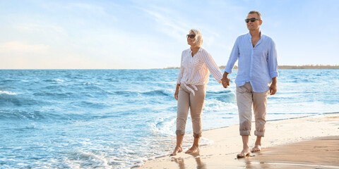 Happy mature couple walking on sea beach