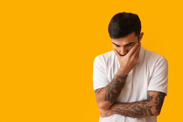 Portrait of worried bearded man on yellow background