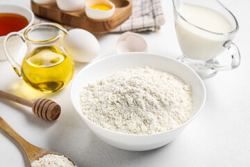 Bowl of flour on light background, closeup