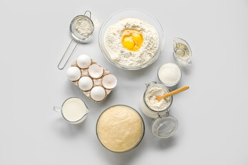 Set of ingredients for baking with raw dough on white background