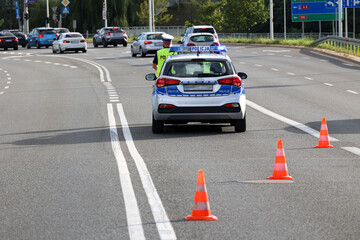 Nowy radiowóz policji polskiej na jezdni podczas zabezpieczenia ruchu drogowego. 