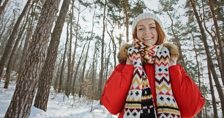 Ginger-haired woman enjoys fresh air in coniferous forest