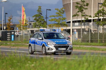 Nowy radiowóz policji polskiej na jezdni podczas zabezpieczenia ruchu drogowego.  - obrazy, fototapety, plakaty