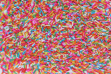 Lots of brightly colored sugar granules background used for topping desserts, cupcakes and ice cream in Top View It's a colorful background suitable for designs and has Copy Space to insert text