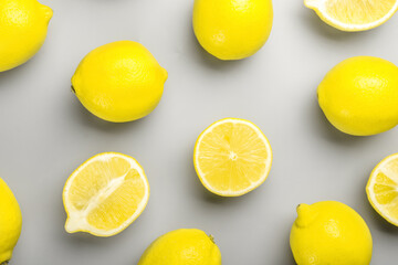 Whole and cut lemons on grey background
