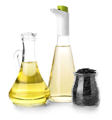 Jugs of oil and sunflower seeds on white background