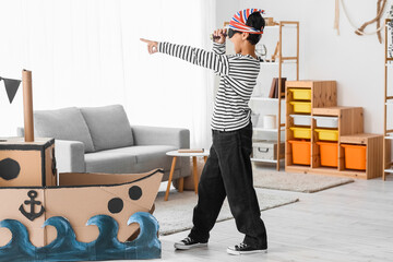 Little boy dressed as pirate with spyglass at home