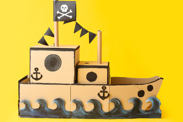 Cardboard pirate ship on yellow background