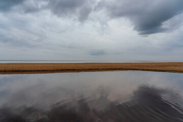 Grey skies and a grey sea with a strip of earth.