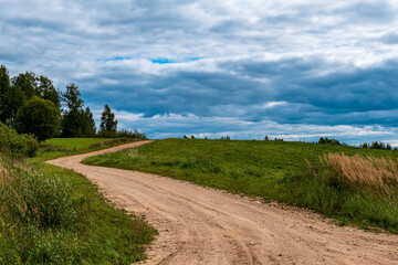 Fototapeta na wymiar A rocky road with a bend leads up a hill.