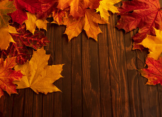 Frame made of autumn dried leaves on dark wooden vintage background. Flat lay, top view, copy space...