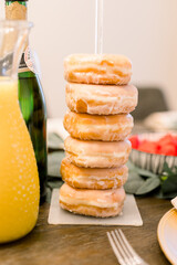 A pile of donuts stacked up on a brunch table set up
