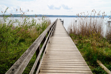 a long wooden pier on lake Ammersee in the beautiful Bavarian village Schondorf (Bavaria, Germany)	