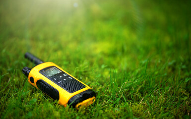 The walkie-talkie for negotiations is yellow. Raindrops in the grass on the radio.