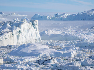 Fototapeta na wymiar Awe-inspiring icy landscapes at the mouth of the Icefjord glacier (Sermeq Kujalleq), one of the fastest and most active glaciers in the world. A UNESCO world heritage site, Ilulissat, Greenland 