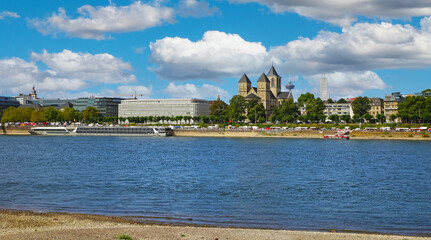 Obraz premium Cologne, Germany - July 9. 2022: View over river rhine on Konrad Adenauer Ufer with St. Kunibert church, blue summer sky